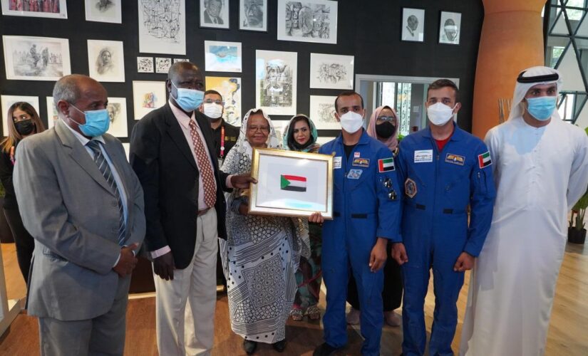 رائد الفضاء الإماراتي الأول يزور جناح السودان ويقدم العلم الوطني